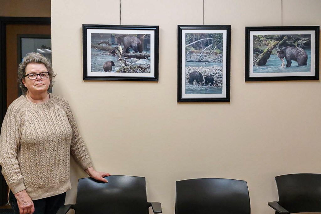 Linda Blokhuisen standing in front of three of the prints in her new exhibit.